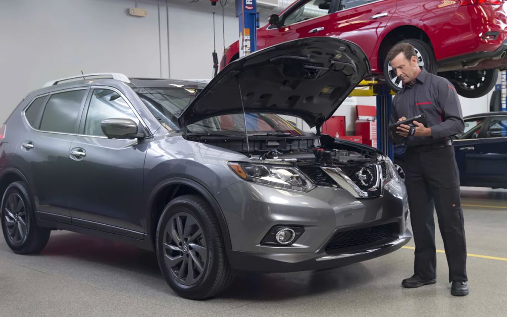 Certified technician completing a Nissan multi-point vehicle inspection in a dealership service department, highlighting expert maintenance, advanced diagnostics, and reliable care.