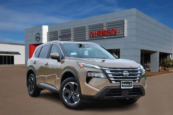 Nissan SUV parked in front of a Nissan dealership showroom building.