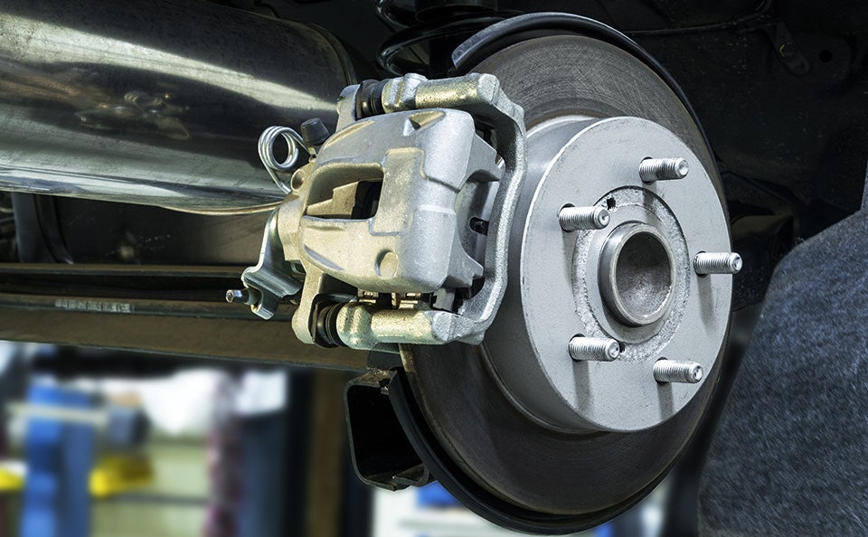 Close-up view of vehicle brake rotor and caliper assembly during automotive brake service.